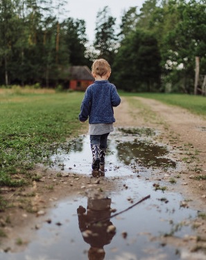 boy walking in puddle